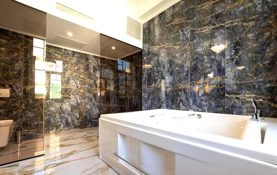 luxurious marble bathroom with large bathtub and glass enclosure