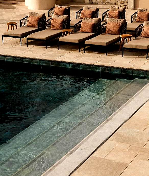 luxurious poolside lounge chairs by infinity pool