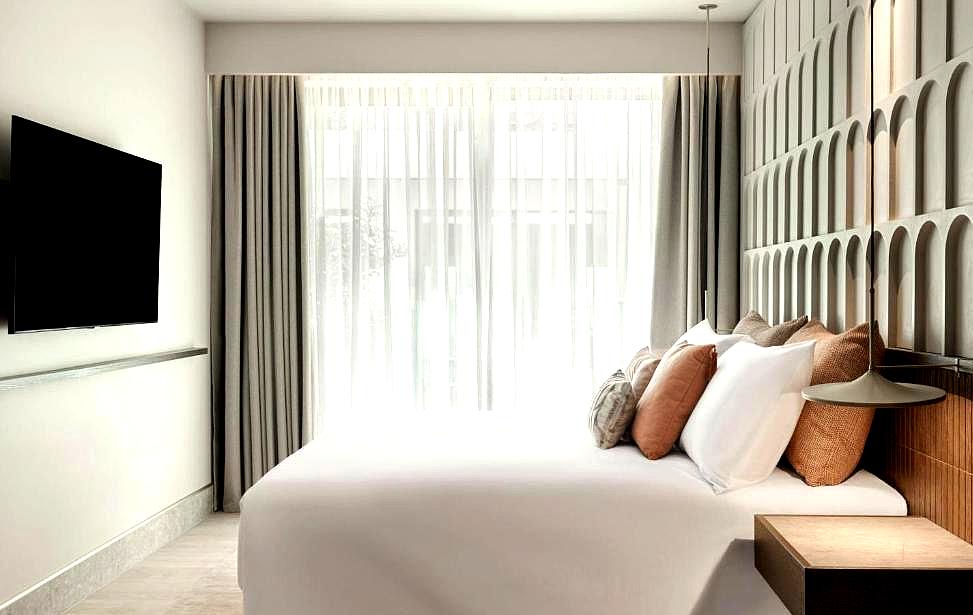 minimalistic hotel room with soft luxury bedding and natural light