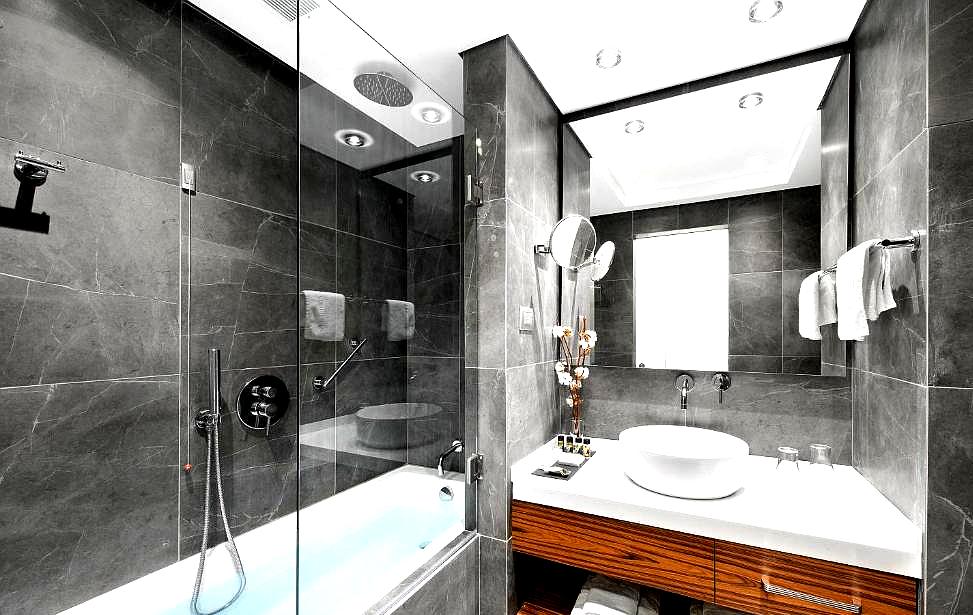 modern bathroom with dark marble tiles and glass shower