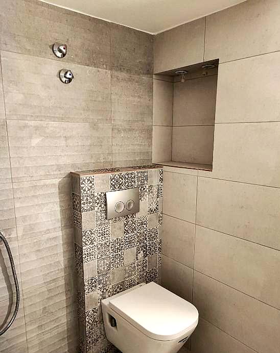 modern bathroom with tiled walls and compact toilet