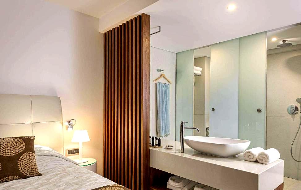 modern hotel room with open concept bathroom and rain shower