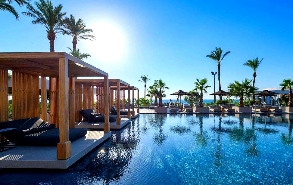 modern poolside cabanas with sea view and palm trees