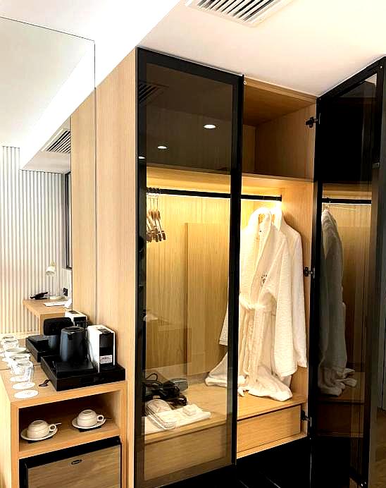 modern suite with wooden walk in closet and coffee station