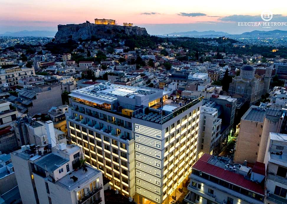 nighttime cityscape with illuminated hotel and acropolis