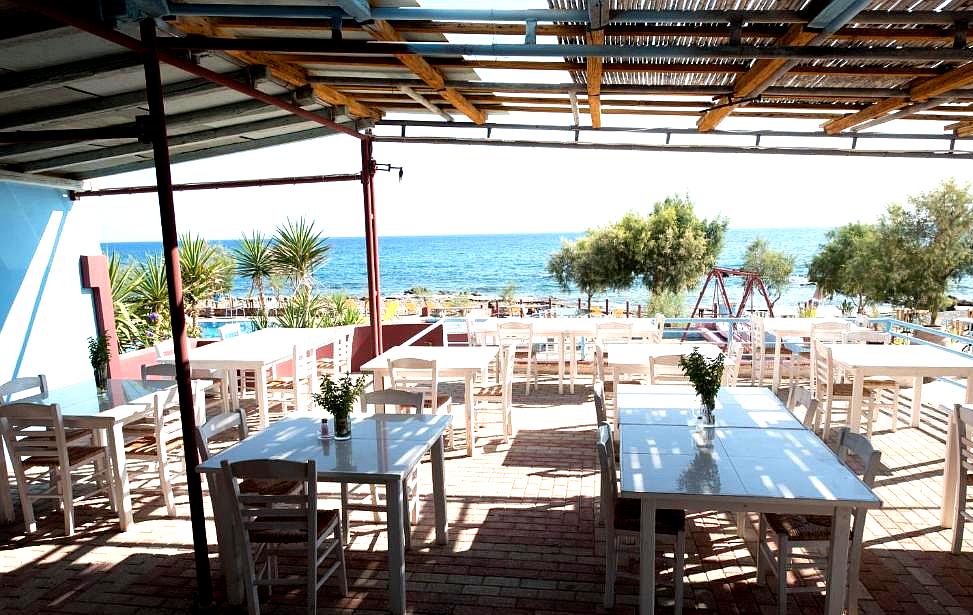 open air restaurant with sea view and white furniture