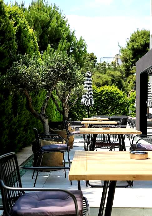 outdoor dining area with garden view and wooden tables