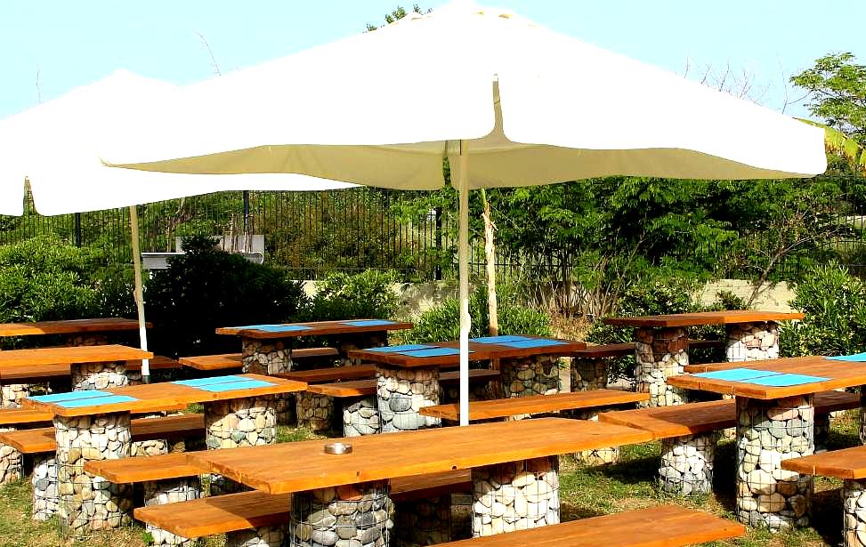 outdoor dining area with wooden tables and umbrellas