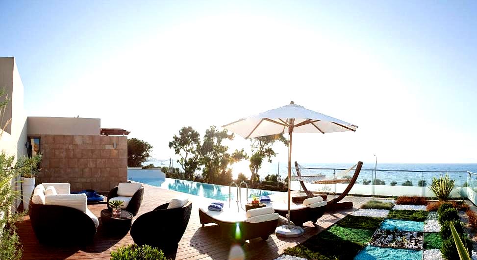 outdoor lounge area with sea view and infinity pool