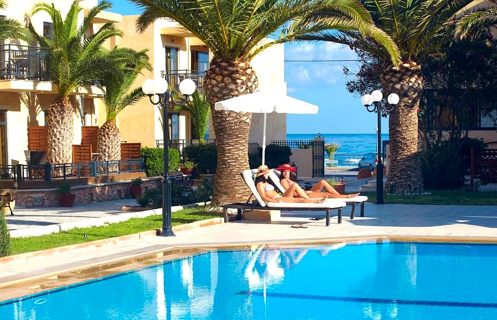 outdoor pool area with palm trees and sea view in resort