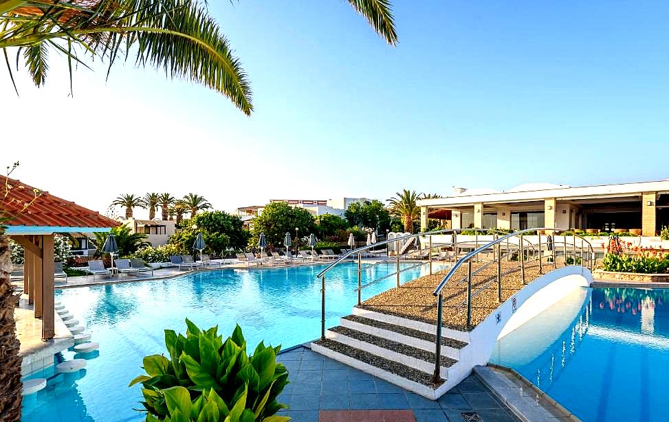 outdoor pool with arched bridge and palm trees