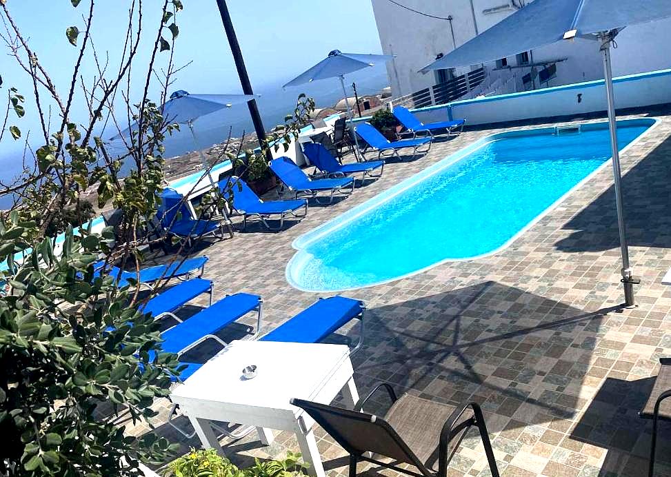 outdoor pool with blue sunbeds and sea view