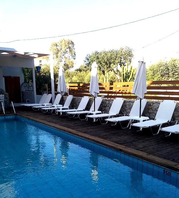 outdoor pool with loungers and wooden deck