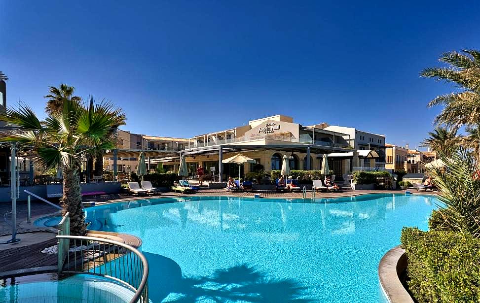 outdoor pool with palm trees and sun loungers in resort