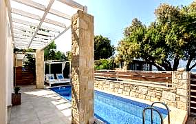 outdoor private pool with lounge chairs and stone walls