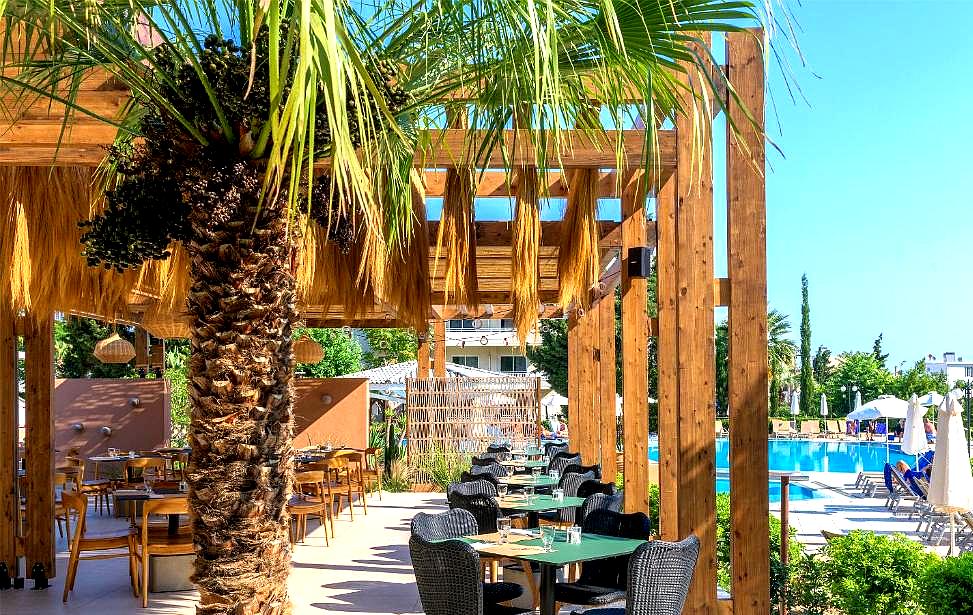 outdoor restaurant with palm trees and pool view