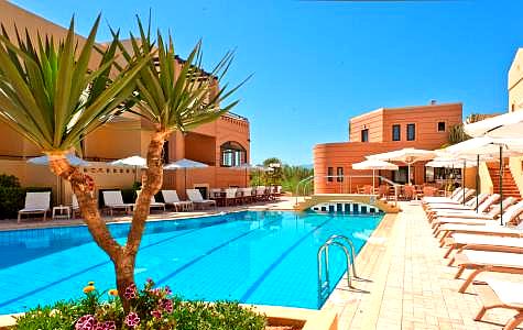 outdoor swimming pool with sun loungers and palm trees