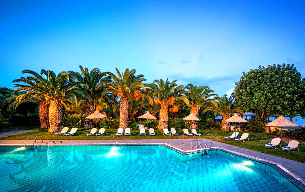 palm lined swimming pool with lounge chairs