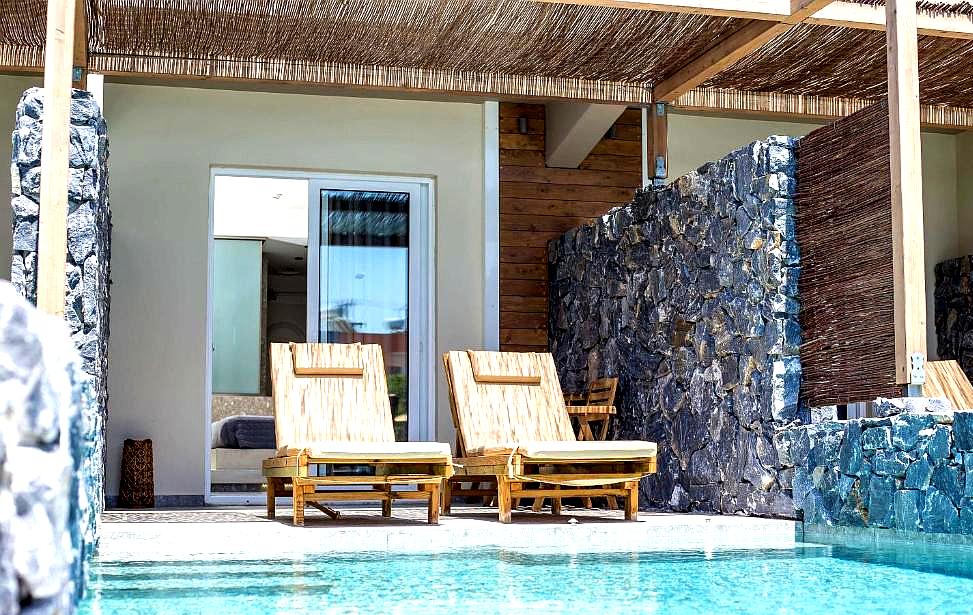 poolside cabanas with wooden lounge chairs at hotel