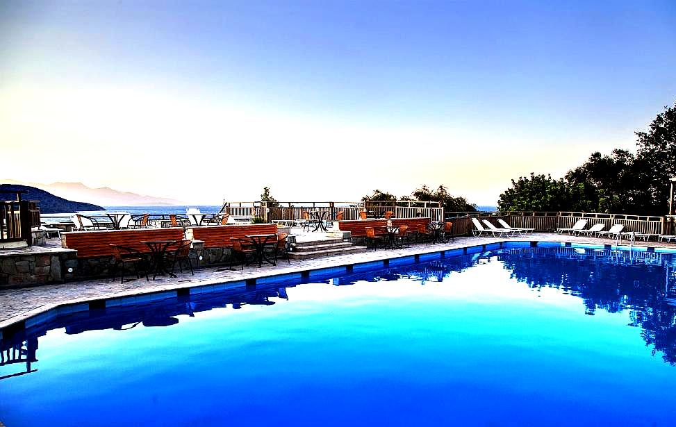 poolside dining area with sea view during sunset