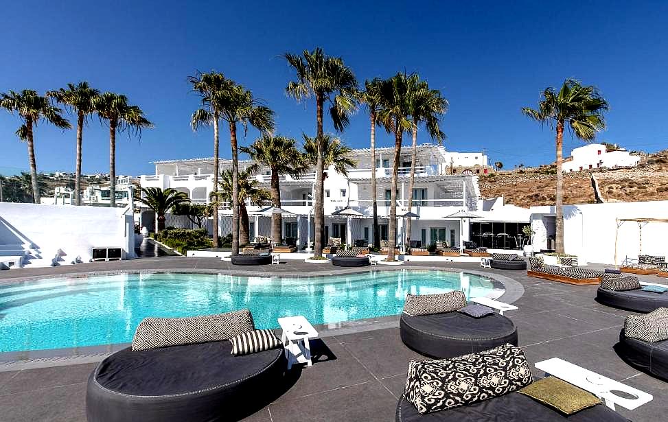 poolside lounge area with round beds and palm trees