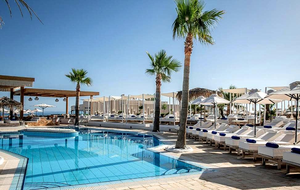 poolside loungers with palm trees and sea view