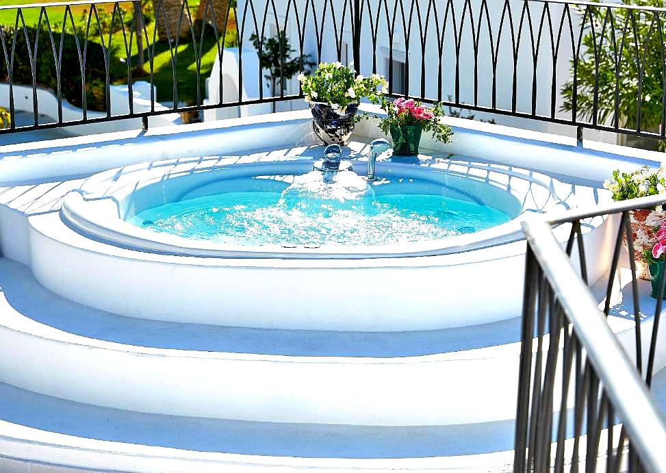 private outdoor jacuzzi with white walls and floral decor