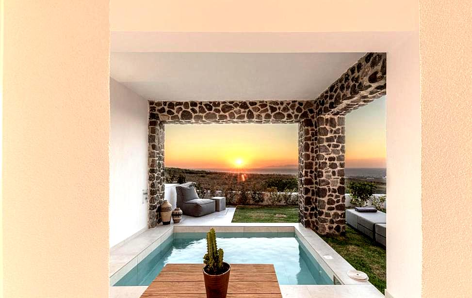 private plunge pool with stone walls and sea view at sunset