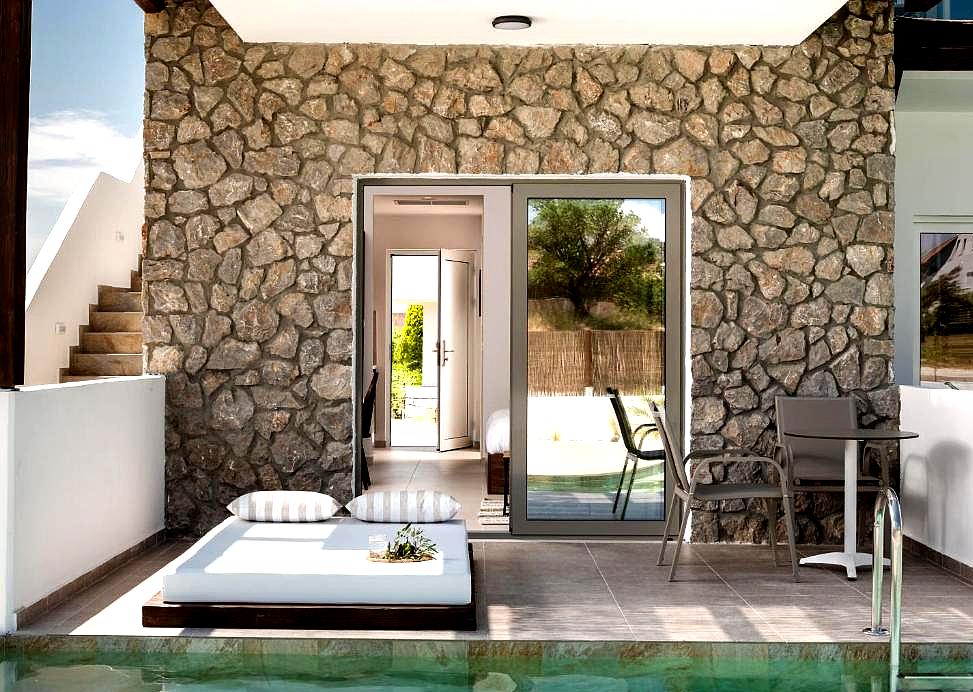 private poolside patio with stone wall and lounge area