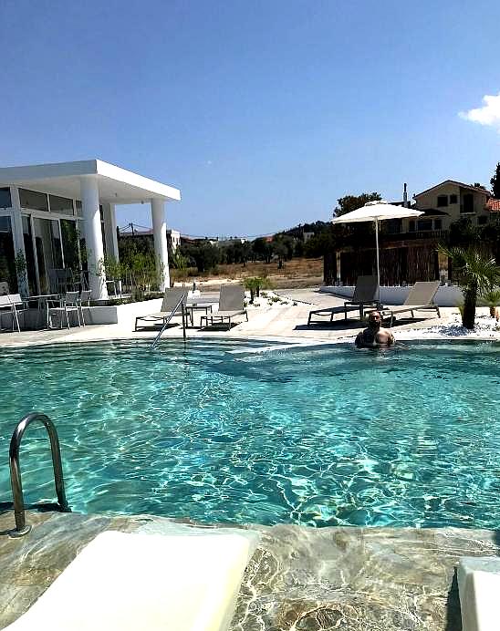 relaxing swimming pool with sun loungers and countryside backdrop