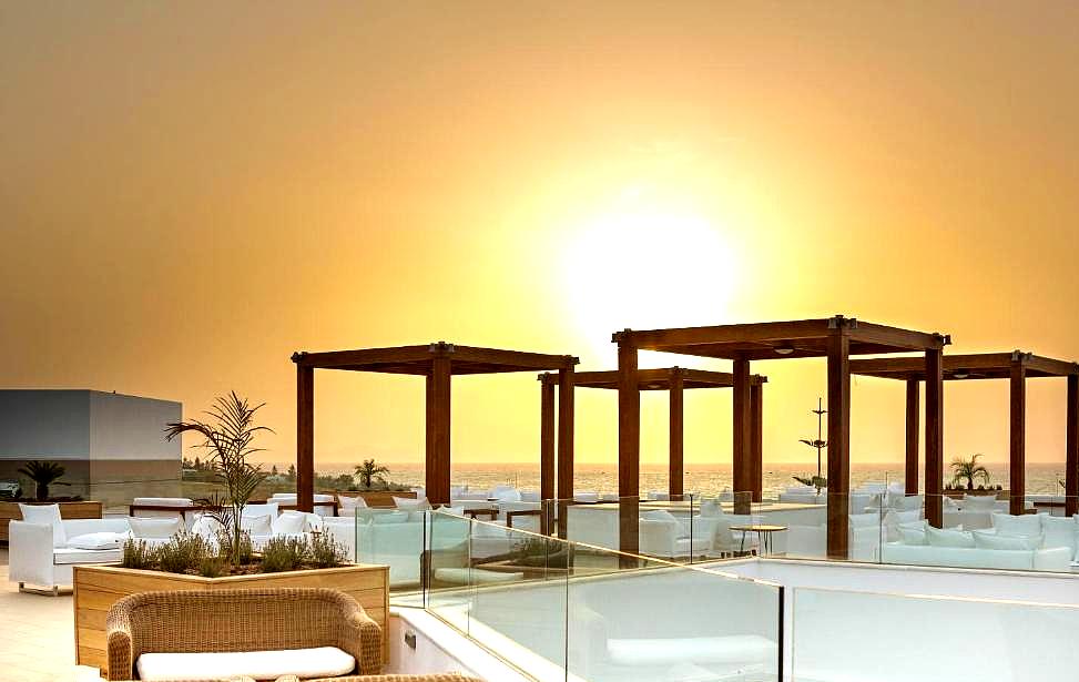 rooftop lounge area with sea view during sunset