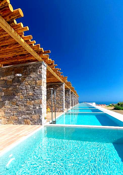 row of private villas with infinity pools and sea view