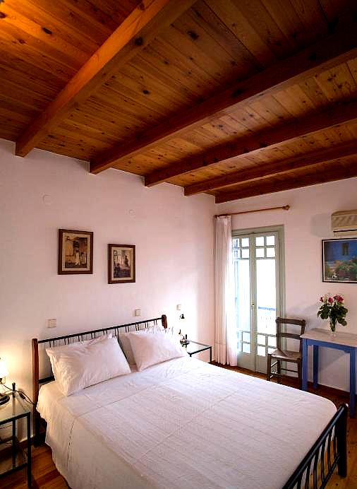 rustic bedroom with wooden ceiling and sea view balcony