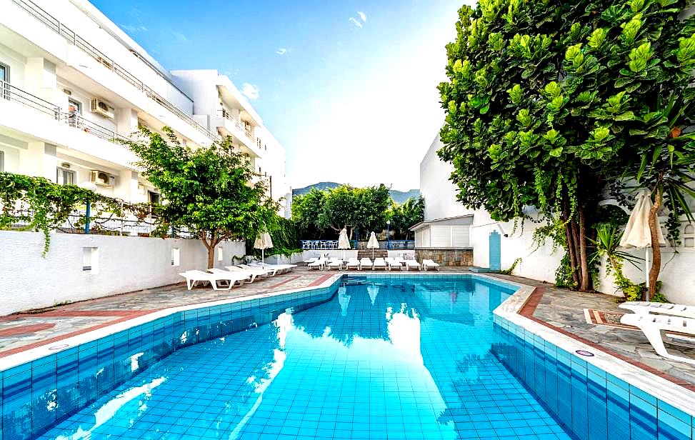 secluded hotel pool area with sun loungers and greenery