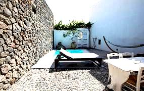 secluded terrace with sun lounger and stone wall