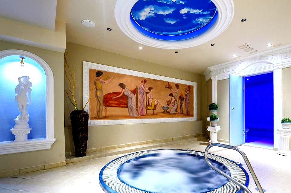 serene indoor hot tub with classical mural and blue lighting