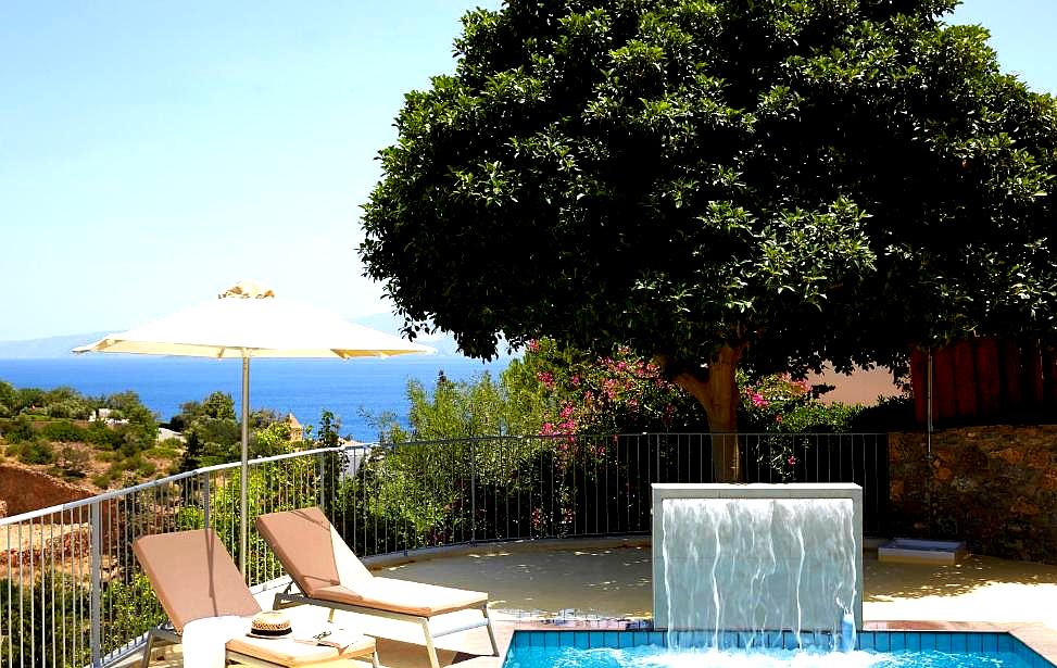 serene poolside with sea view and shaded loungers