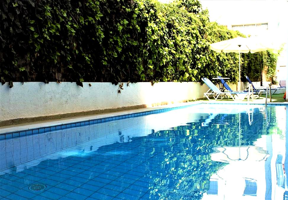 serene private pool with sun loungers and greenery