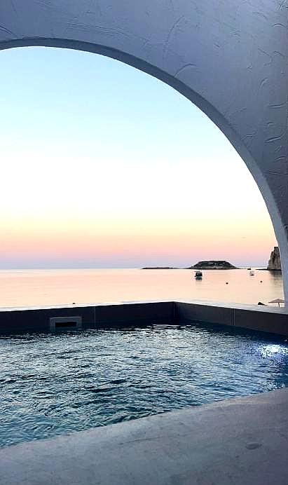 serene sea view from infinity pool under arched roof