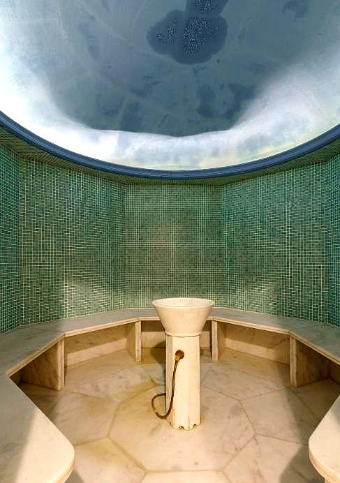 serene spa room with circular marble seating and mosaic tiles