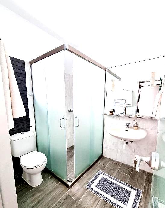 spacious bathroom with frosted glass shower