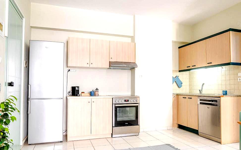 spacious kitchenette with modern appliances and light wood cabinets