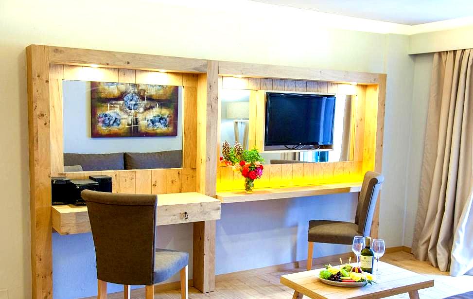 spacious suite with wooden furniture and dining area