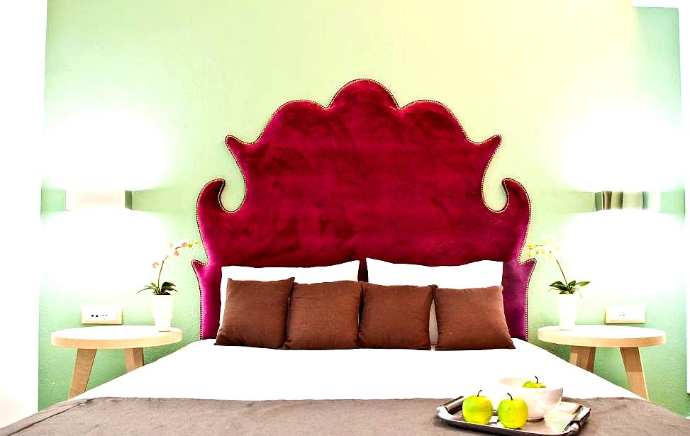 stylish hotel room with vibrant red headboard and cozy bed