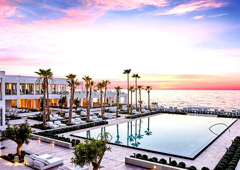 sunset over luxury swimming pool with ocean view