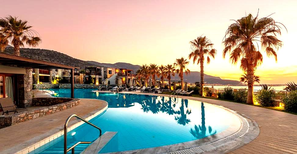 sunset pool with sea view and palm trees