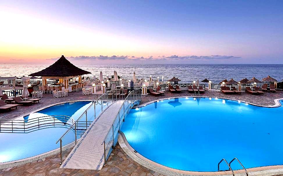 sunset view of pool with sea and bridge