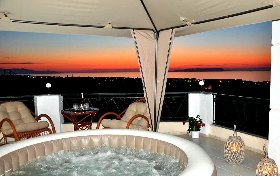 terrace with hot tub and sea view at sunset