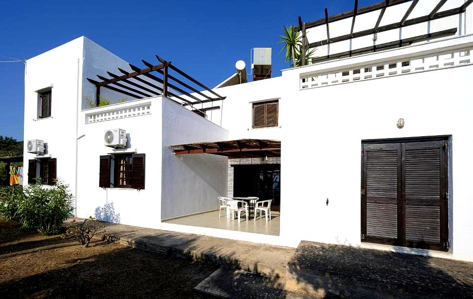 traditional white washed building with wooden shutters and patio