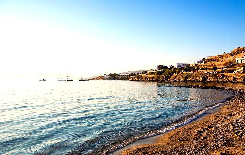 tranquil beachfront with sandy shore and sailboats